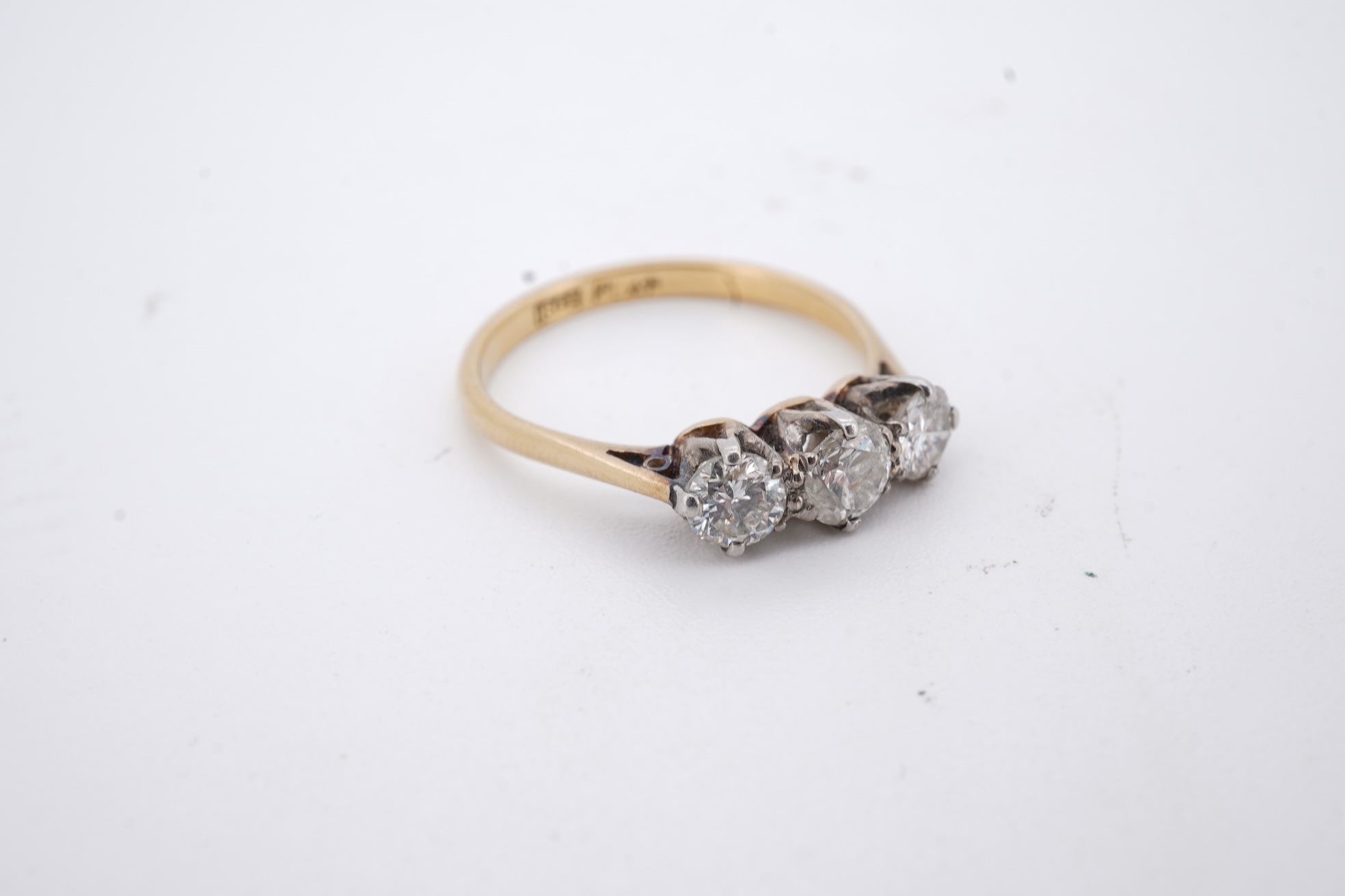 A yellow metal (stamped 18ct, & plat) and three stone diamond set ring, size L, gross weight 2.1 grams.